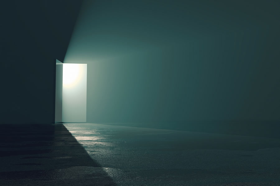 Door opening to light in dark room